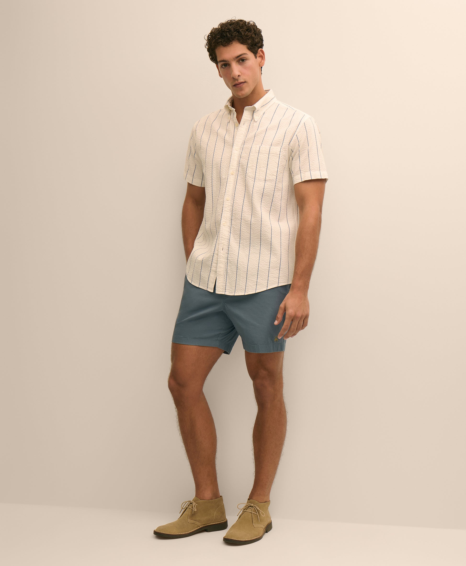 Man wearing a striped shirt, shorts, and shoes