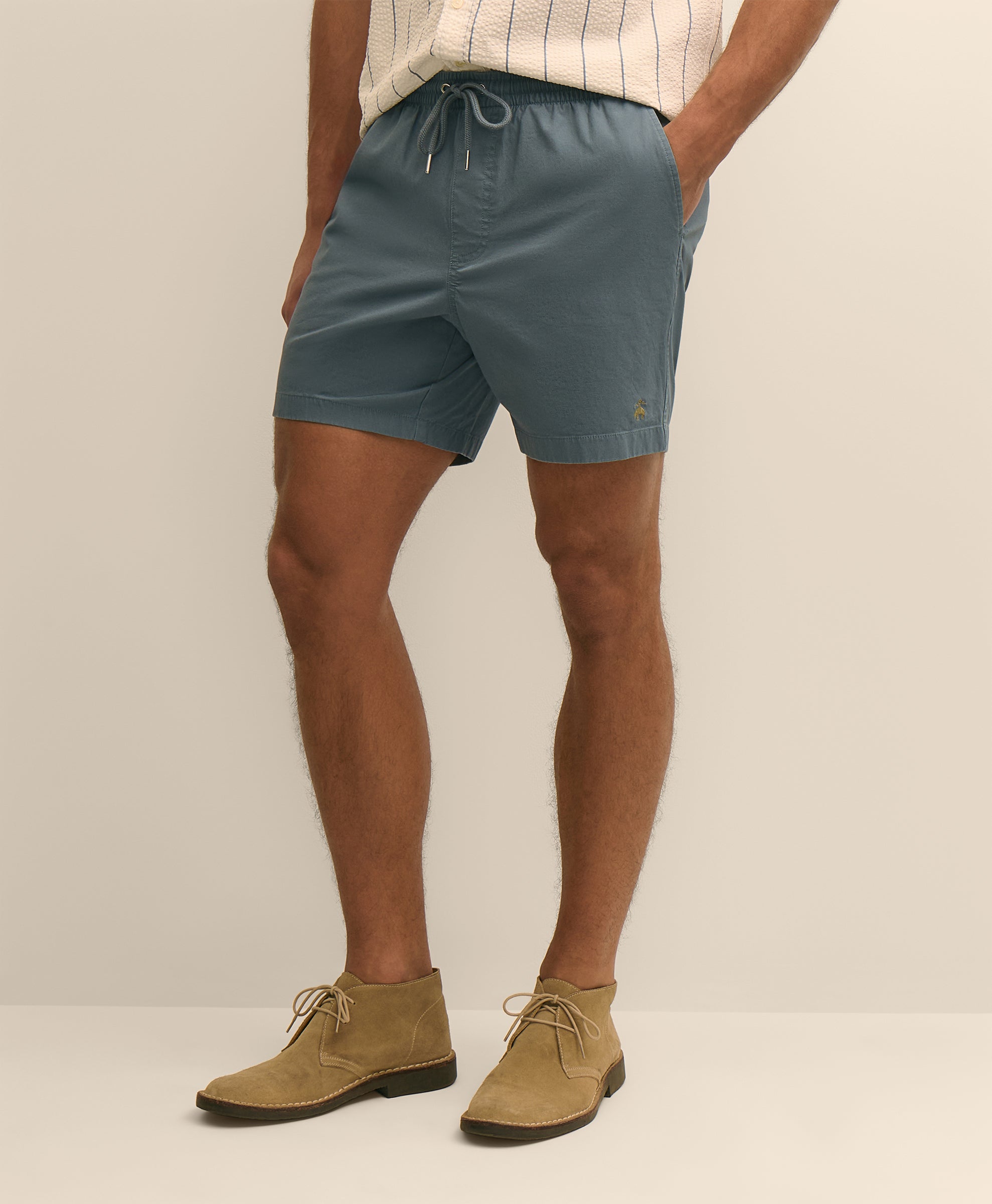 Person wearing teal shorts and brown shoes