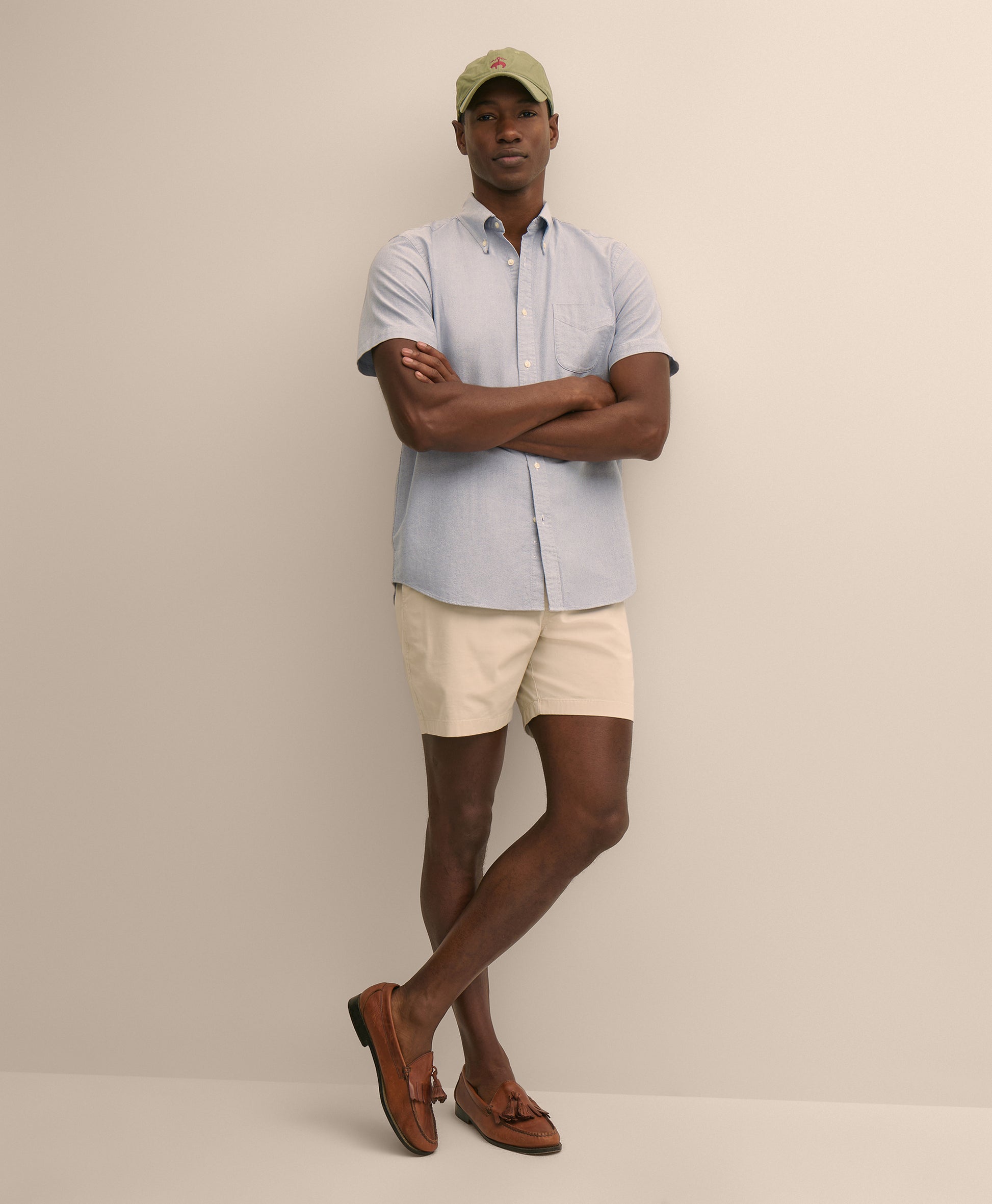 Man wearing a light blue shirt, beige shorts, and brown shoes