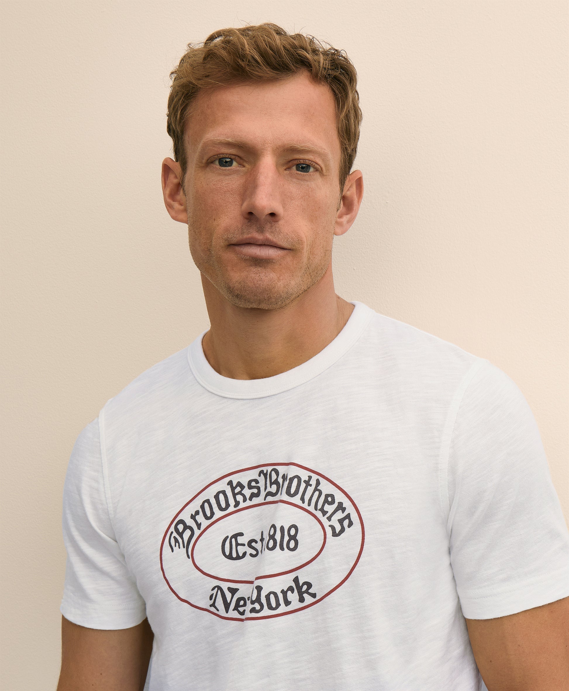 Man wearing a white t-shirt with Brooks Brothers logo
