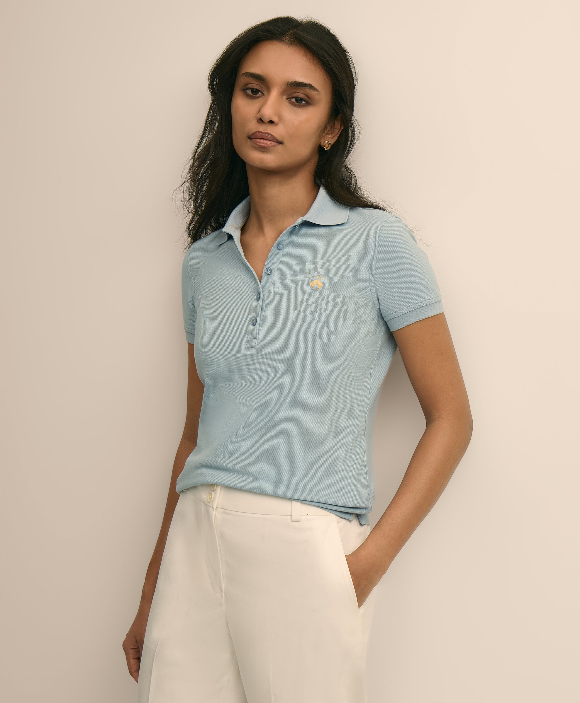 Woman wearing a light blue polo shirt with a logo