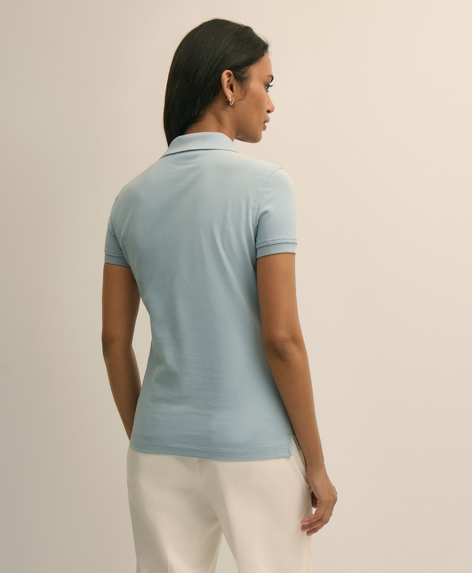 Woman wearing a light blue polo shirt