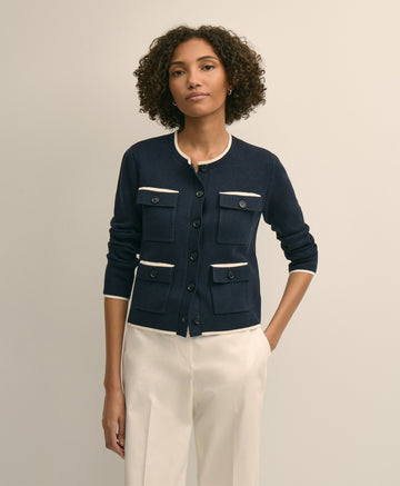 Woman wearing a navy blue cardigan with white trim