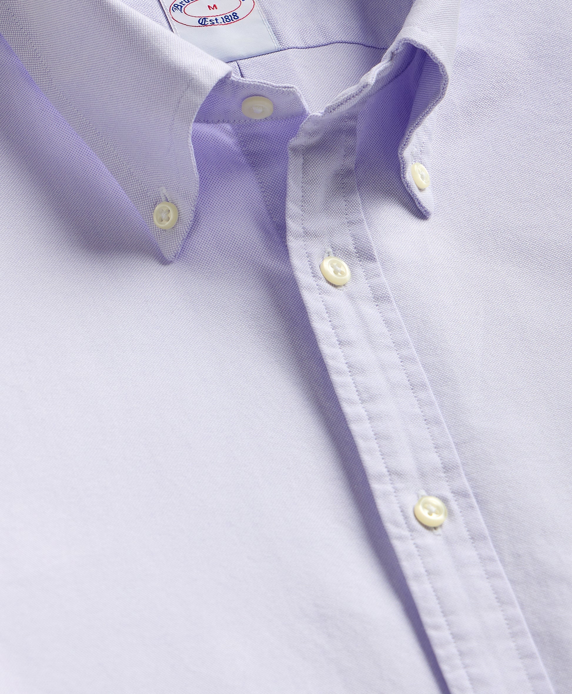 Close-up of a light purple dress shirt with collar and buttons.