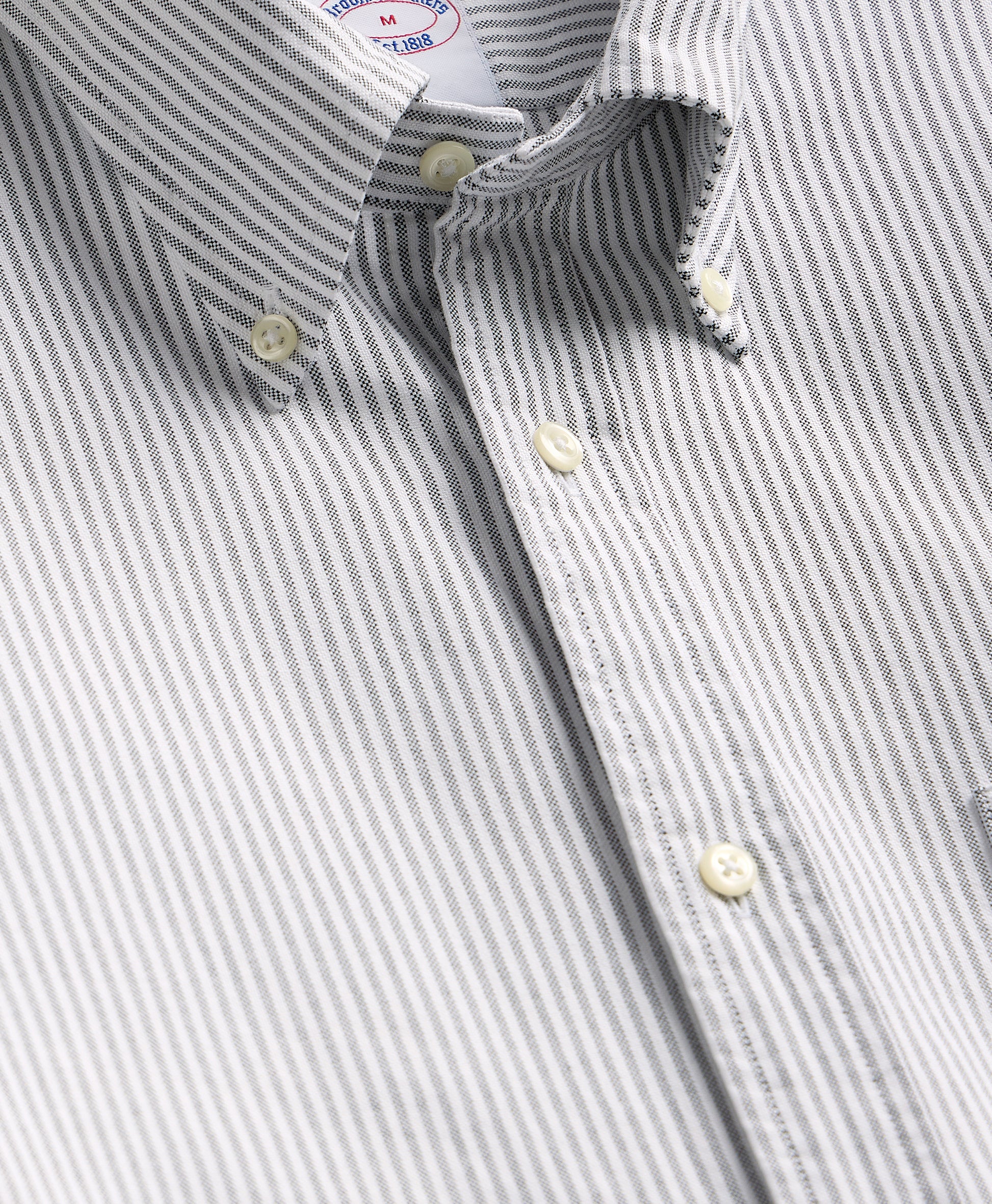 Close-up of a gray and white striped shirt with a collar and buttons.