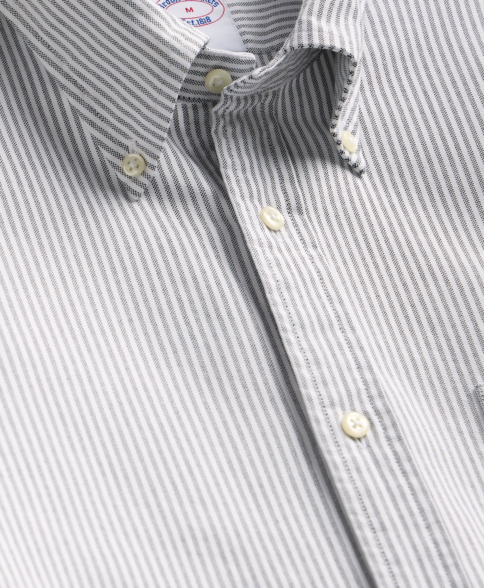 Close-up of a gray and white striped shirt with a collar and buttons.