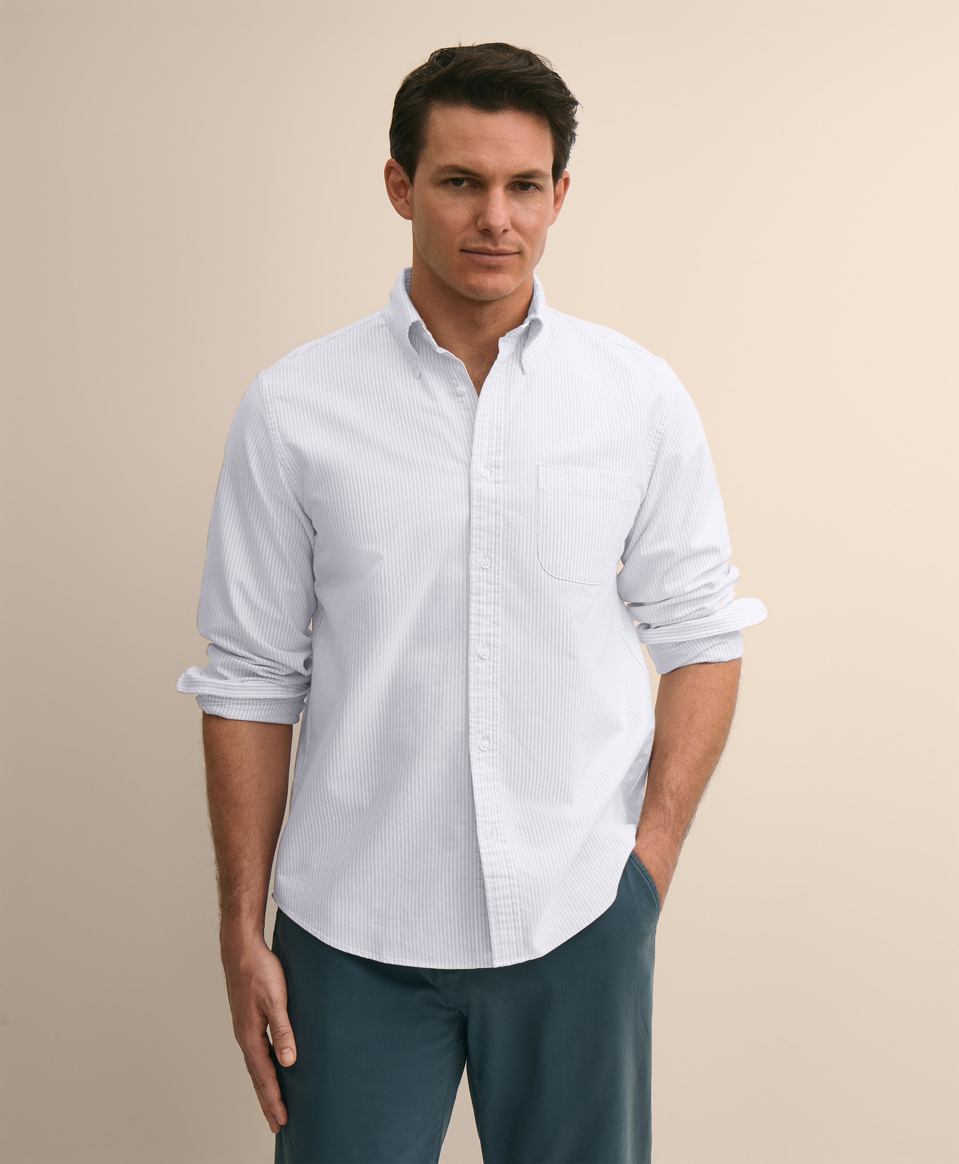 Man wearing a light blue button-up shirt and dark pants