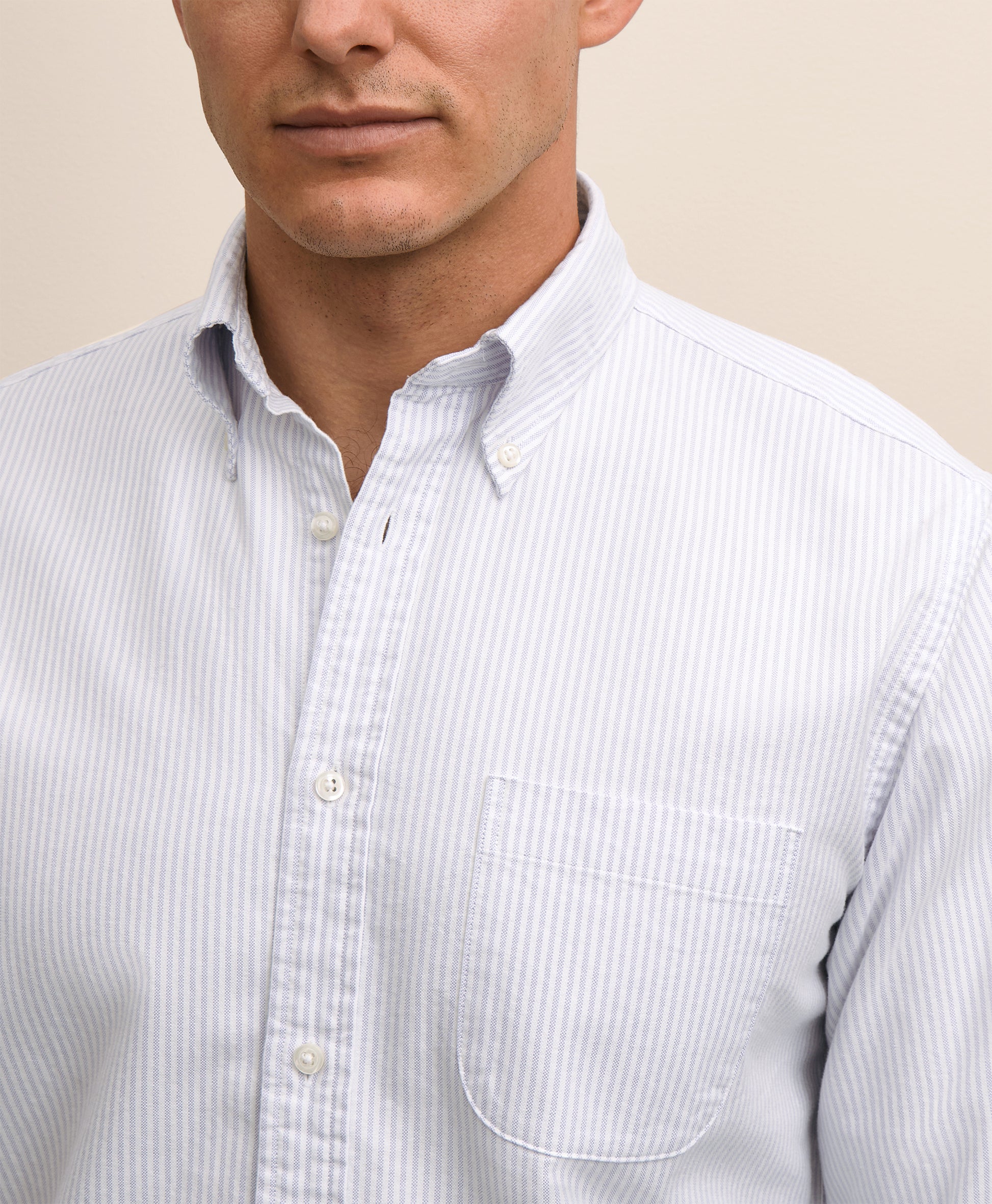 Close-up of a man wearing a light blue striped shirt