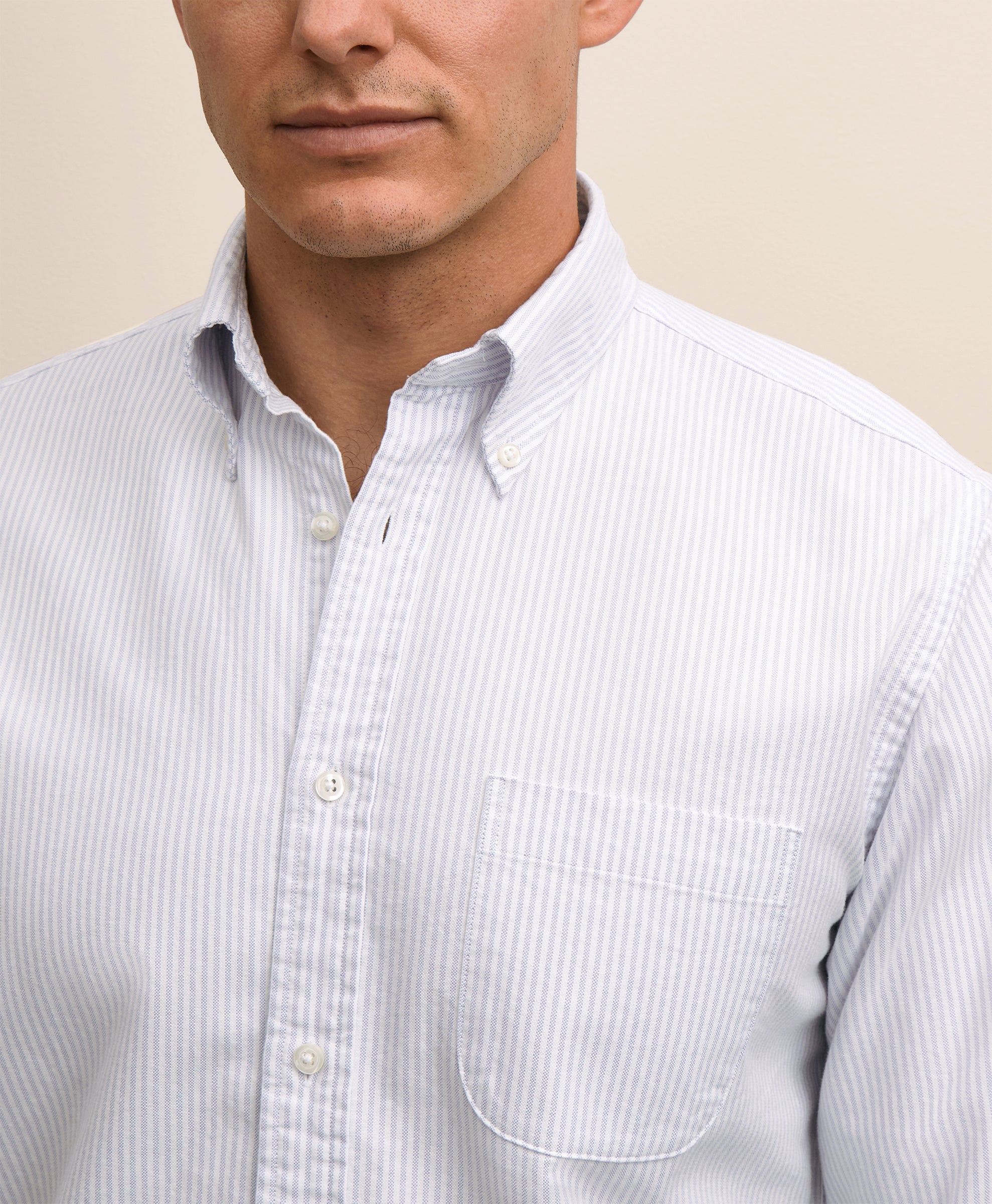 Close-up of a man wearing a light blue striped shirt