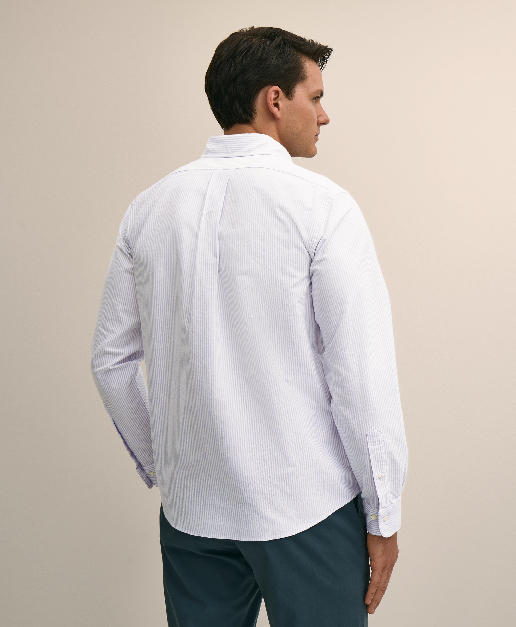Man wearing a white patterned shirt and dark pants