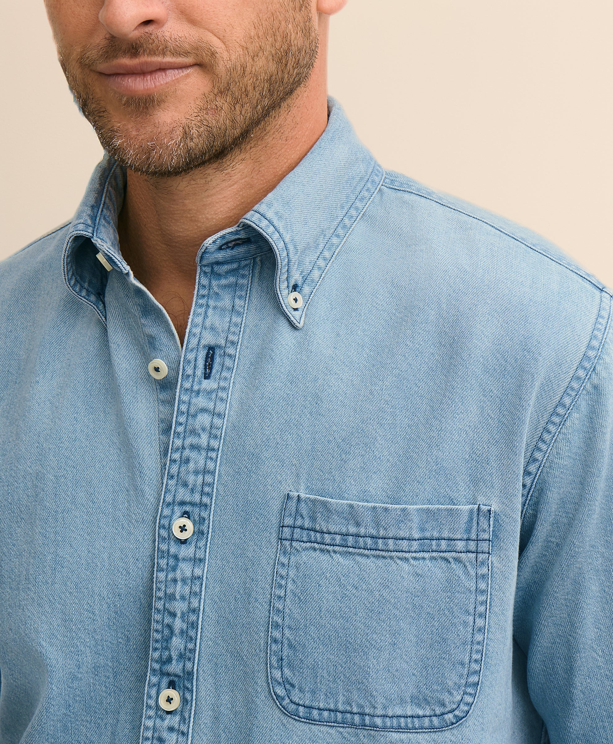Close-up of a man wearing a light blue denim shirt