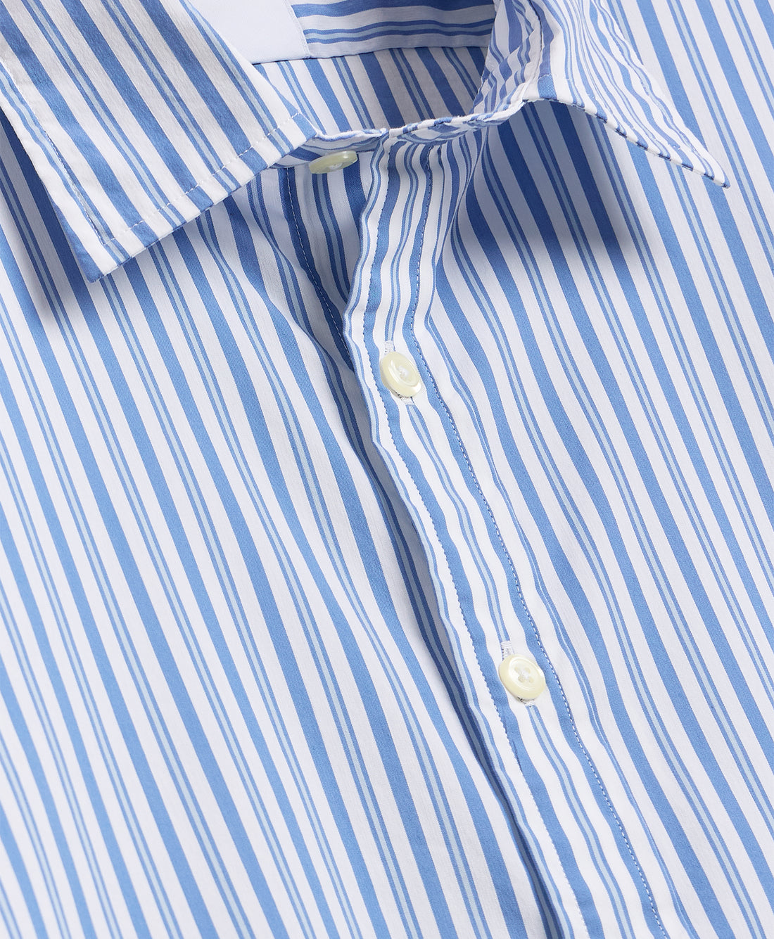Close-up of button-down collar and anchor print on navy fabric.