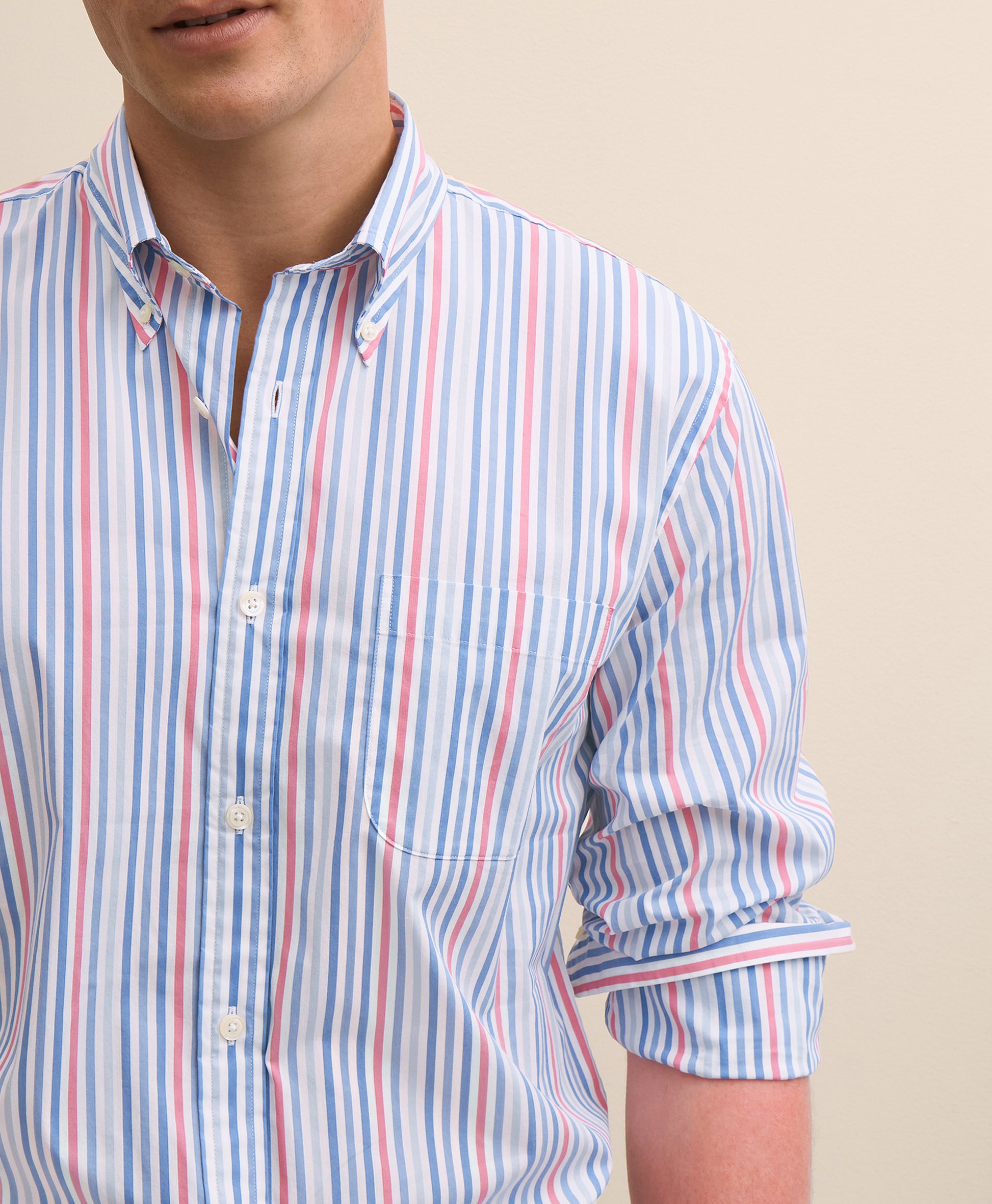Close-up of a person wearing a striped shirt with rolled-up sleeves