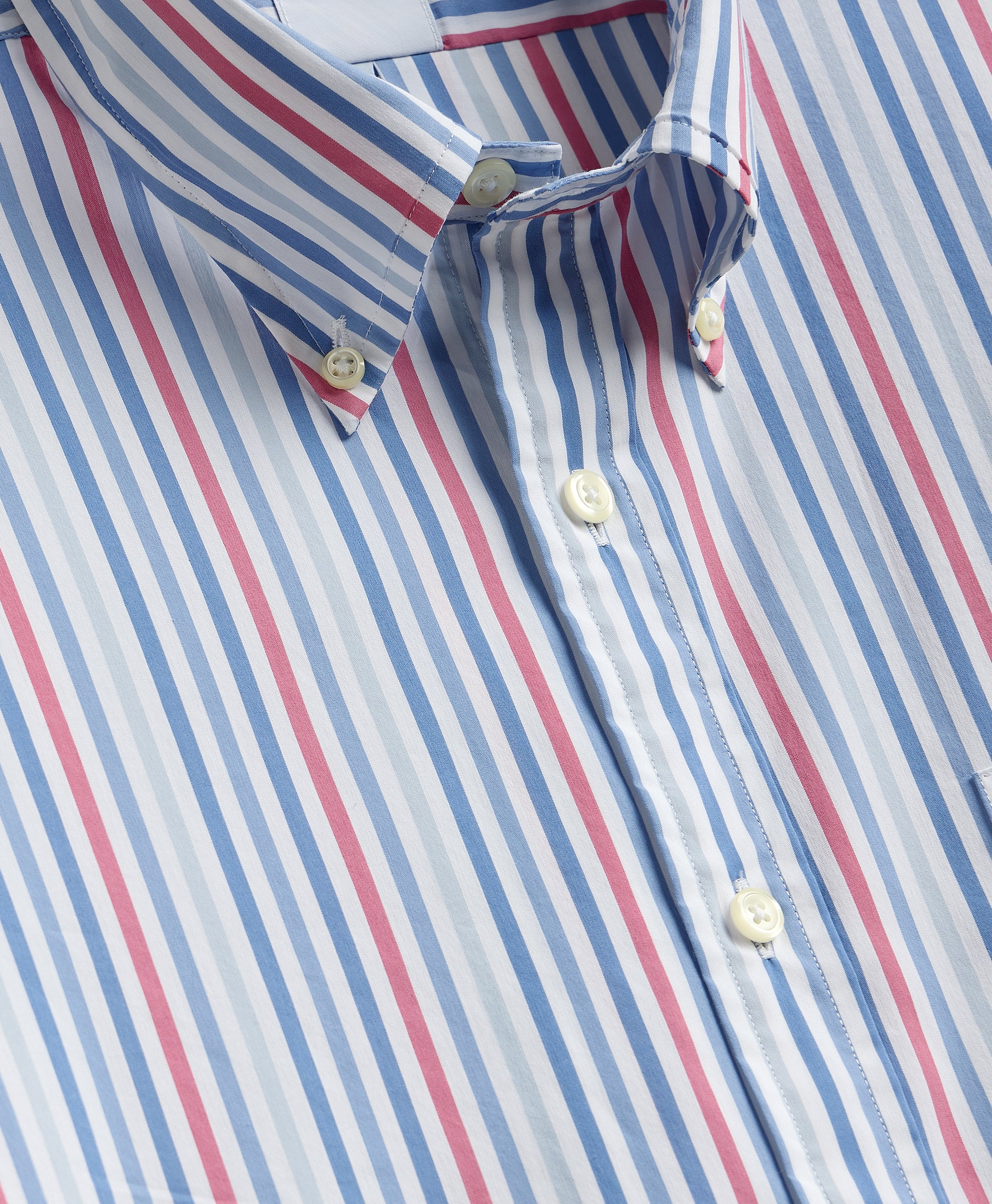 Close-up of a striped shirt with red, blue, and white horizontal stripes.