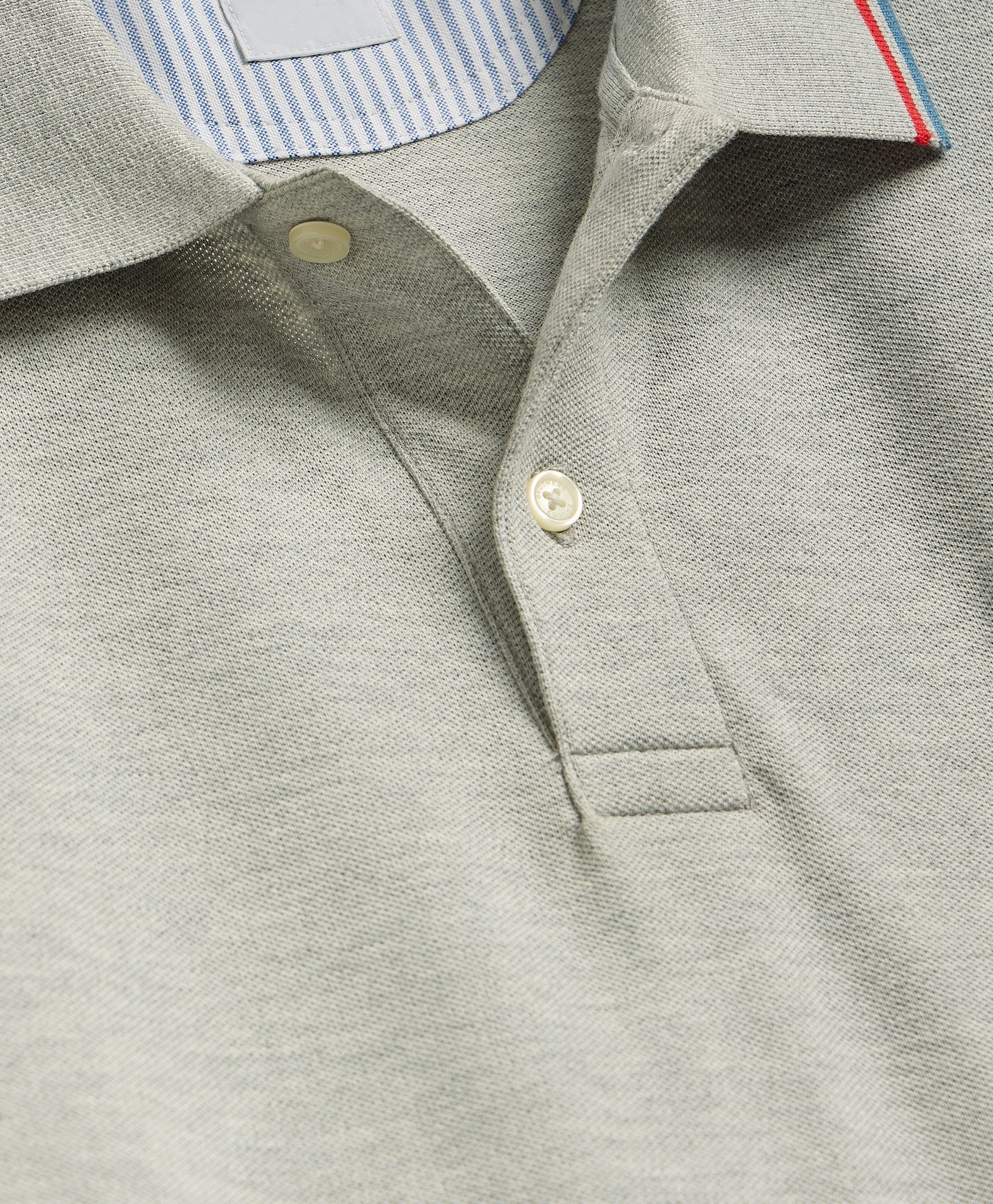 Close-up of a gray polo shirt with a button and collar detail.