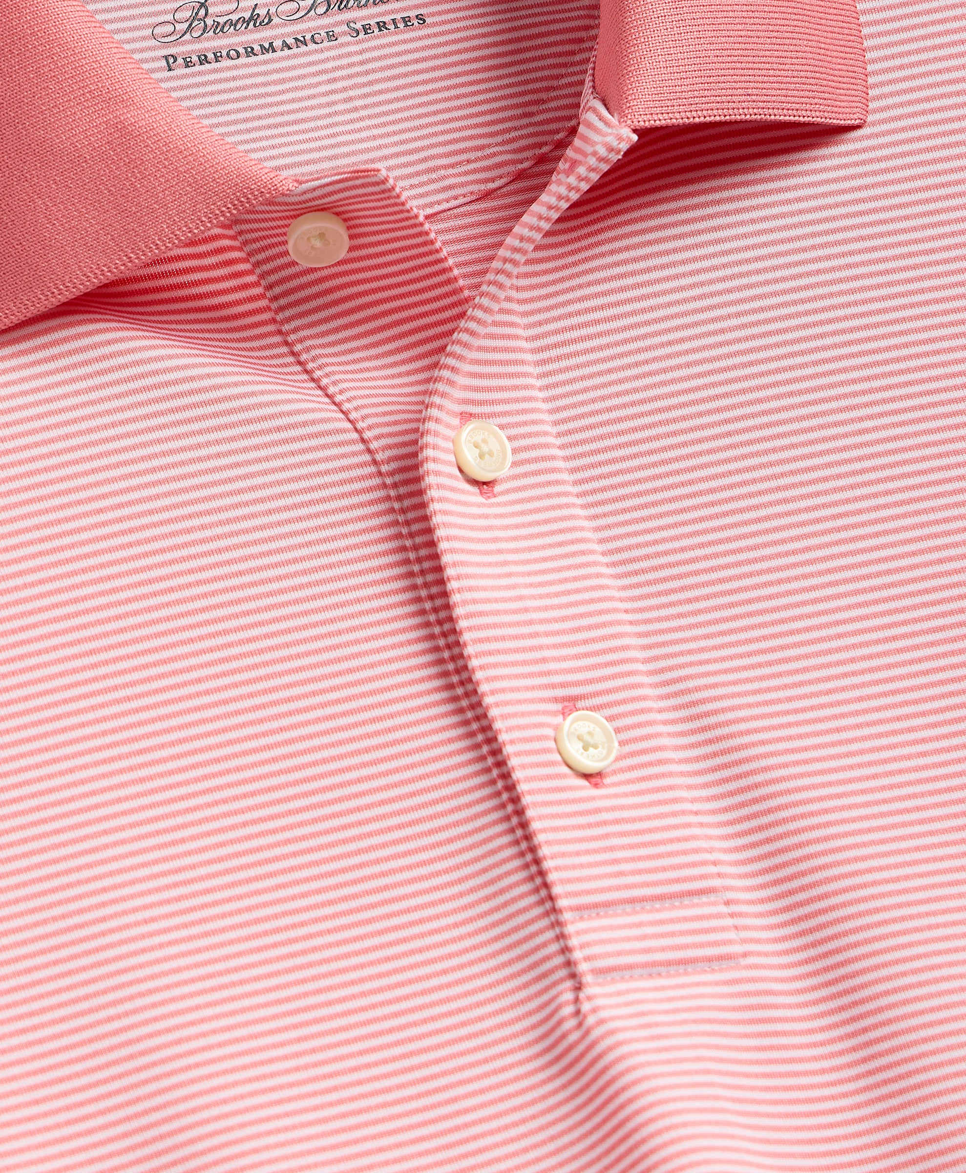 Close-up of a pink and white striped shirt with button details.