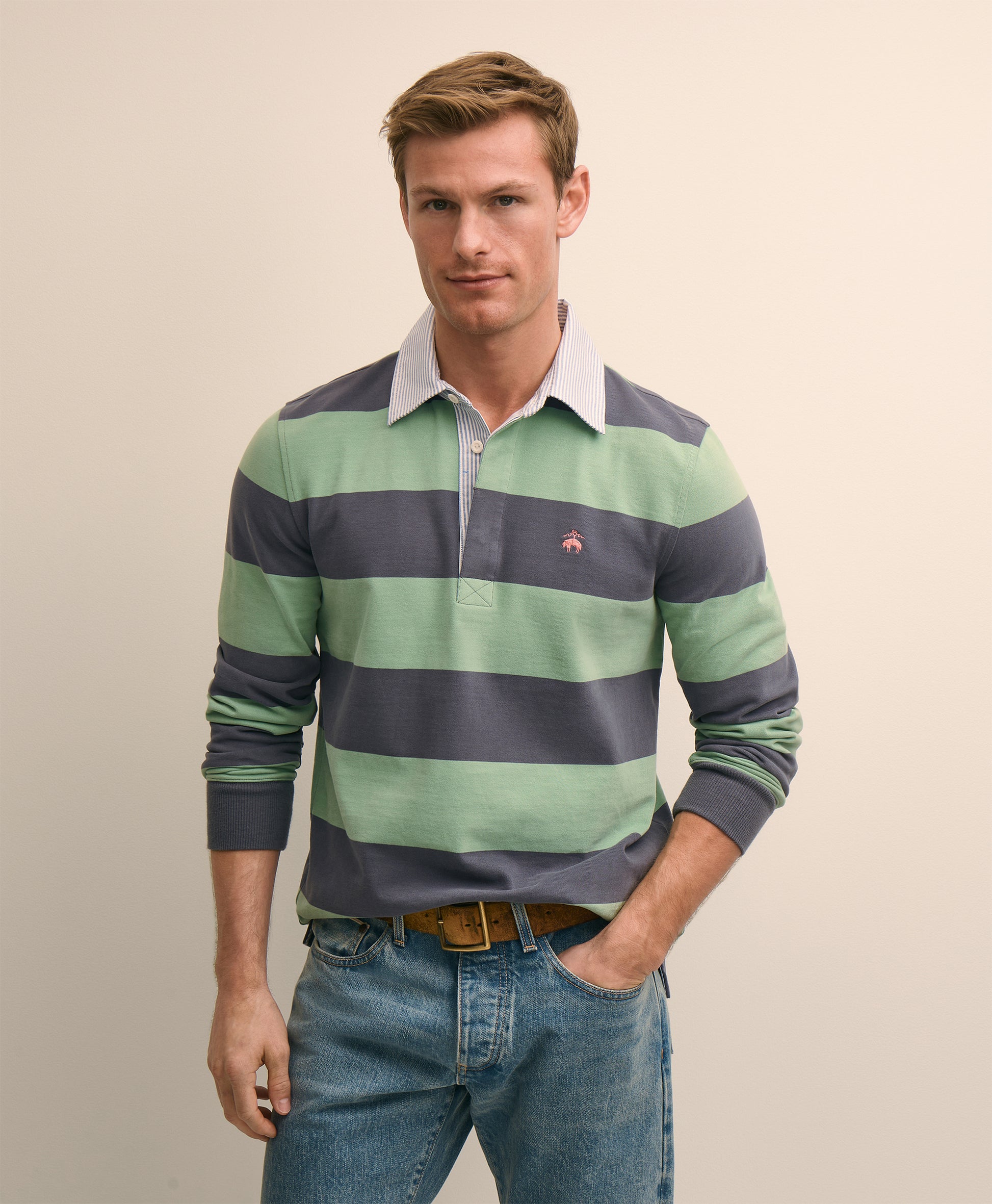 Man wearing a green and navy striped long-sleeve shirt with a visible brand logo