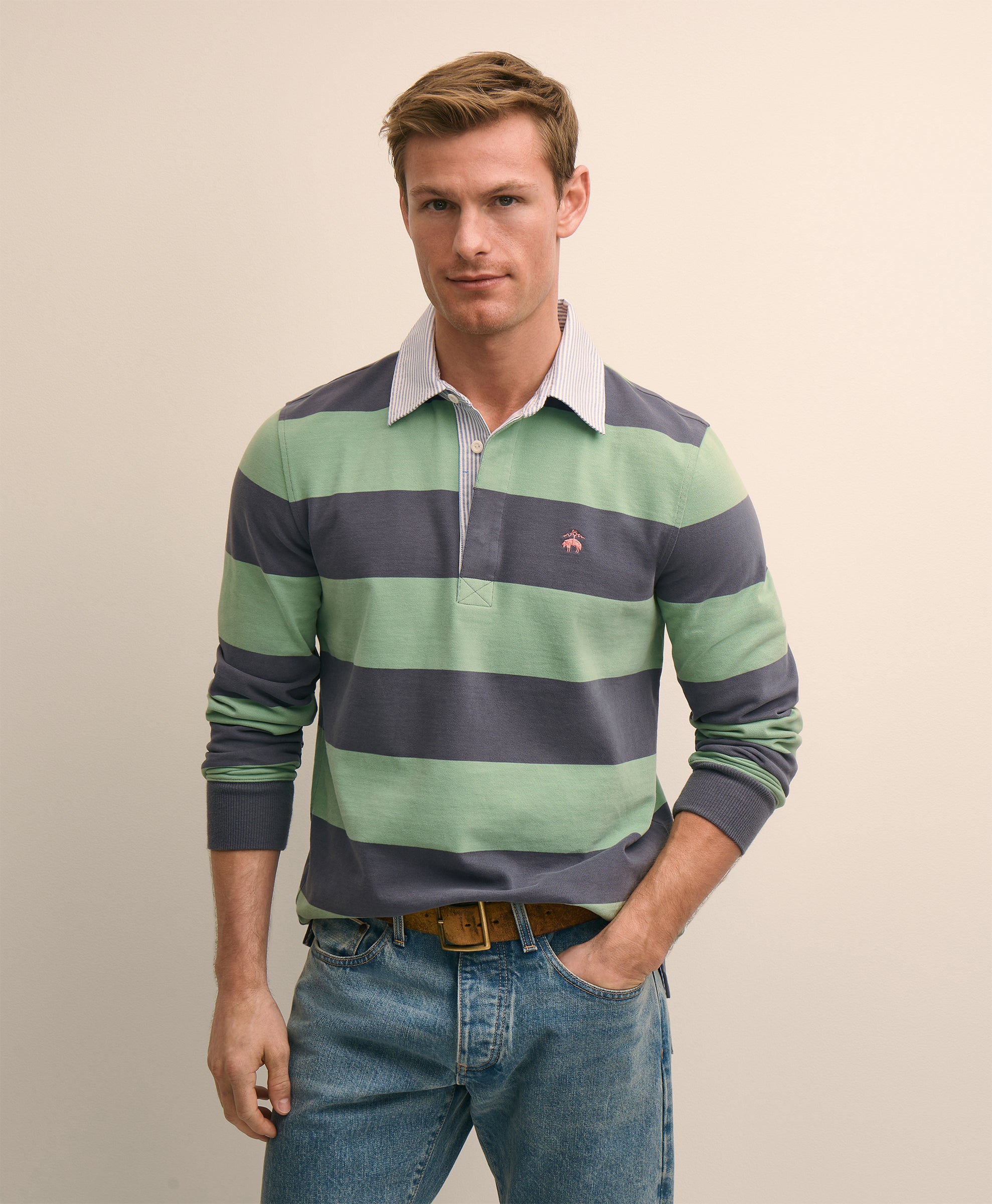 Man wearing a green and navy striped long-sleeve shirt with a visible brand logo