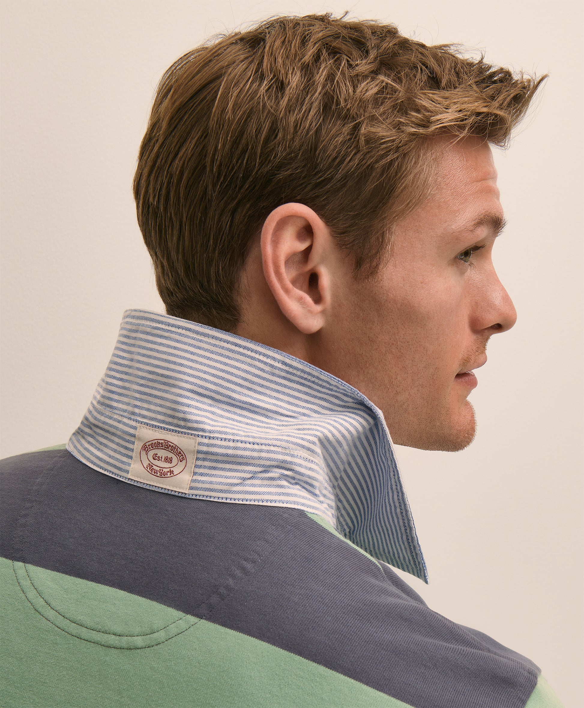Man wearing a striped neckerchief with a visible brand label
