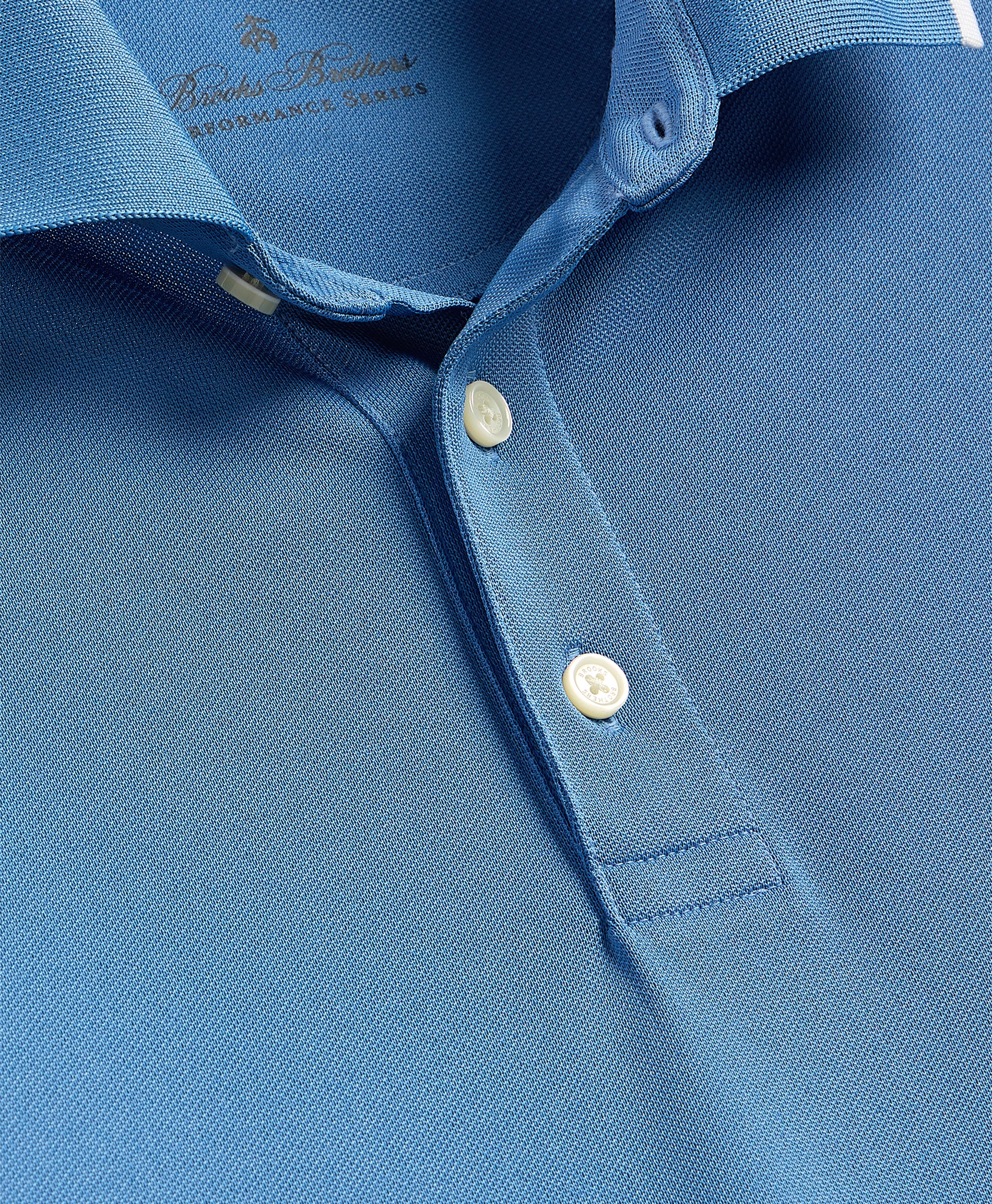 Close-up of a blue polo shirt with brand logo