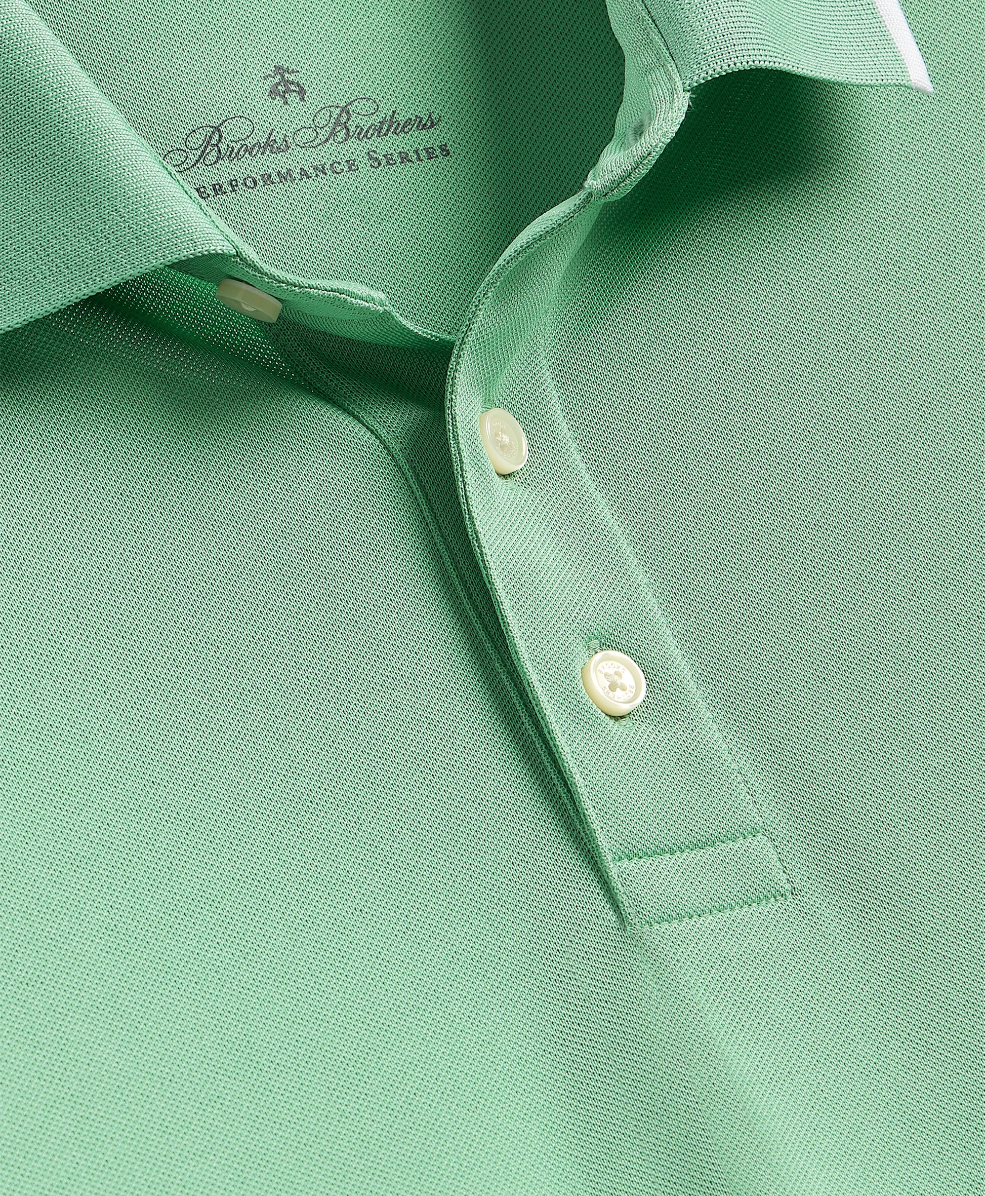 Close-up of a green polo shirt with button details and Brooks Brothers branding.