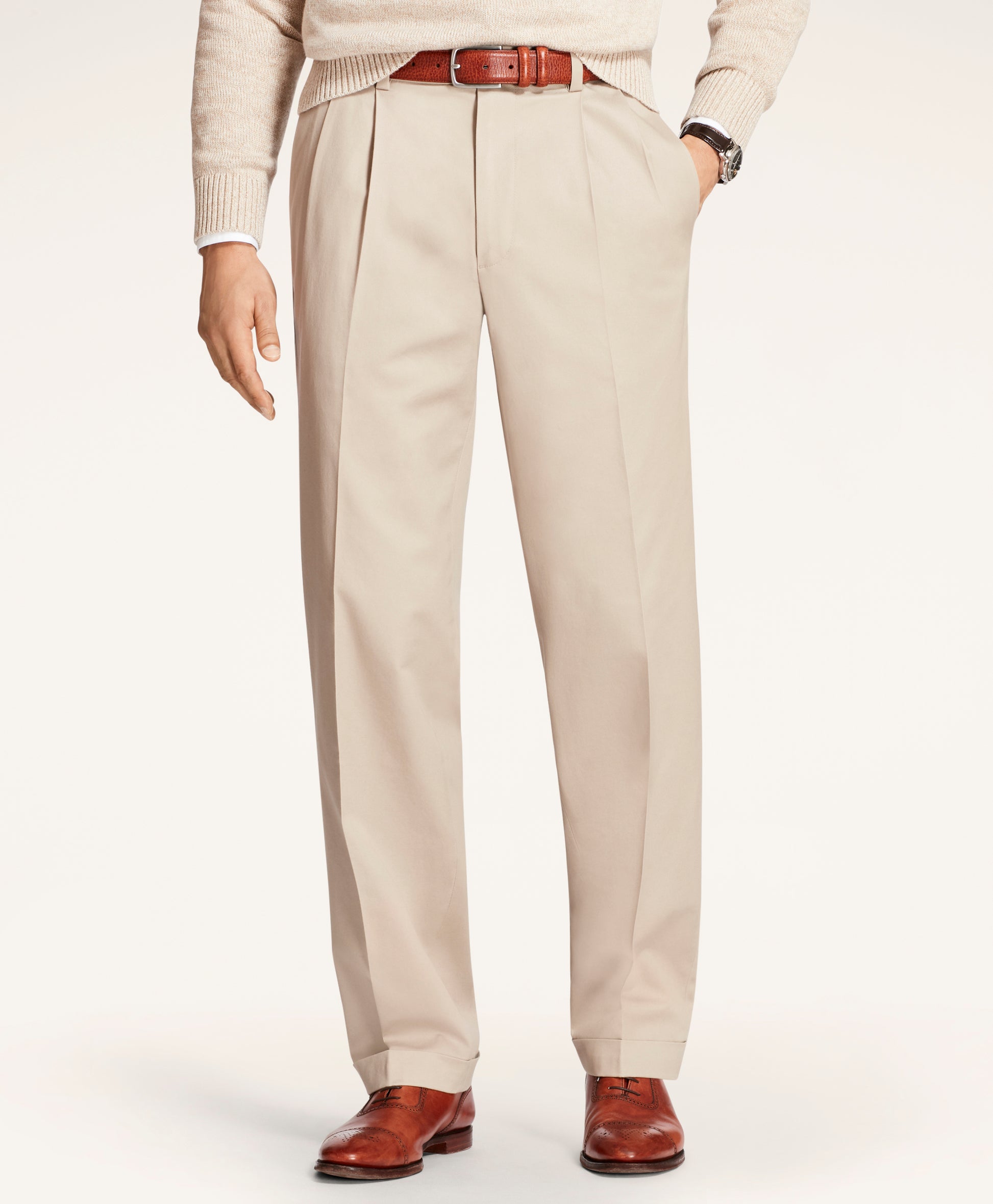 Beige dress pants worn with a white sweater and brown shoes