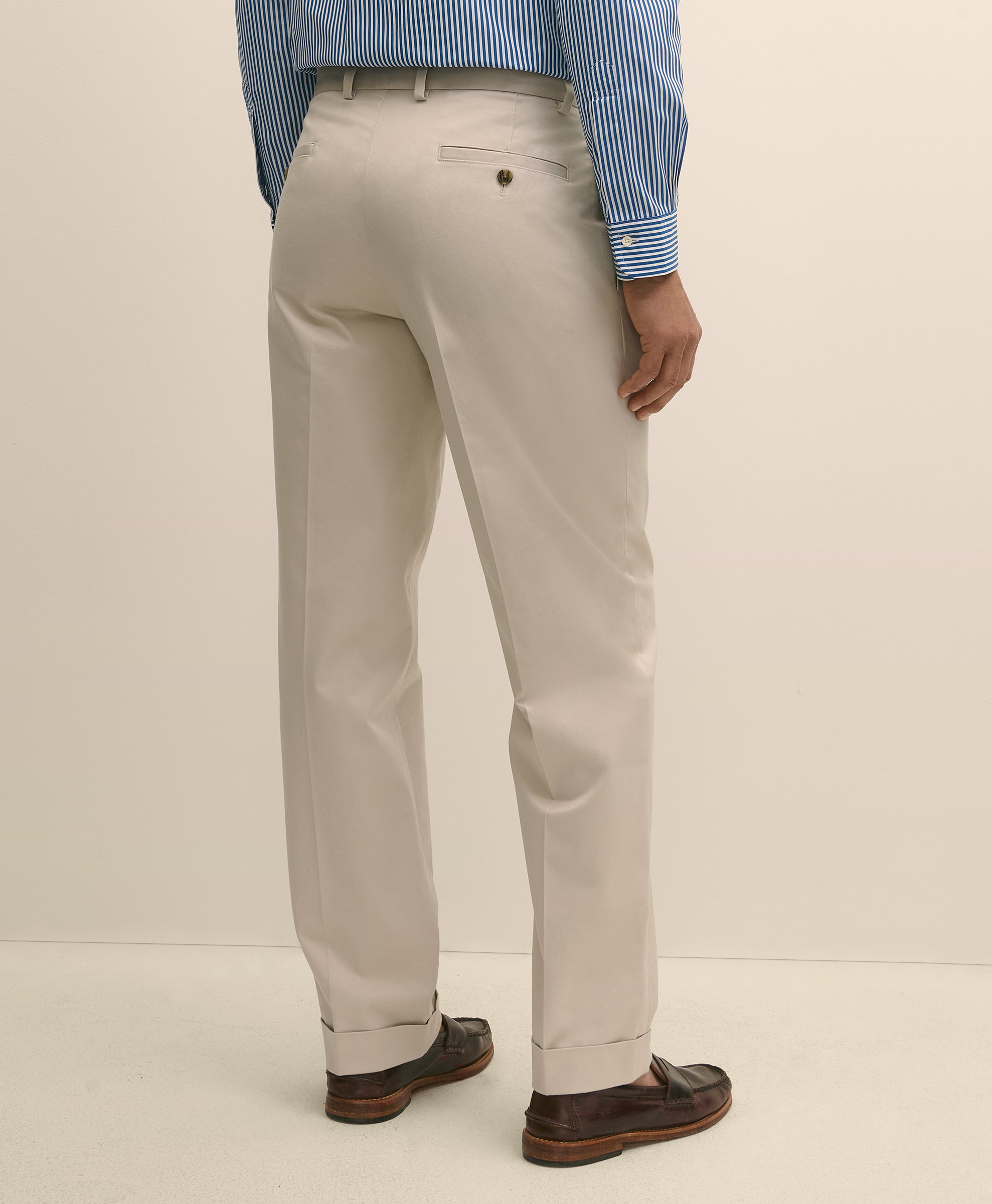 Person wearing beige dress pants with a blue striped shirt