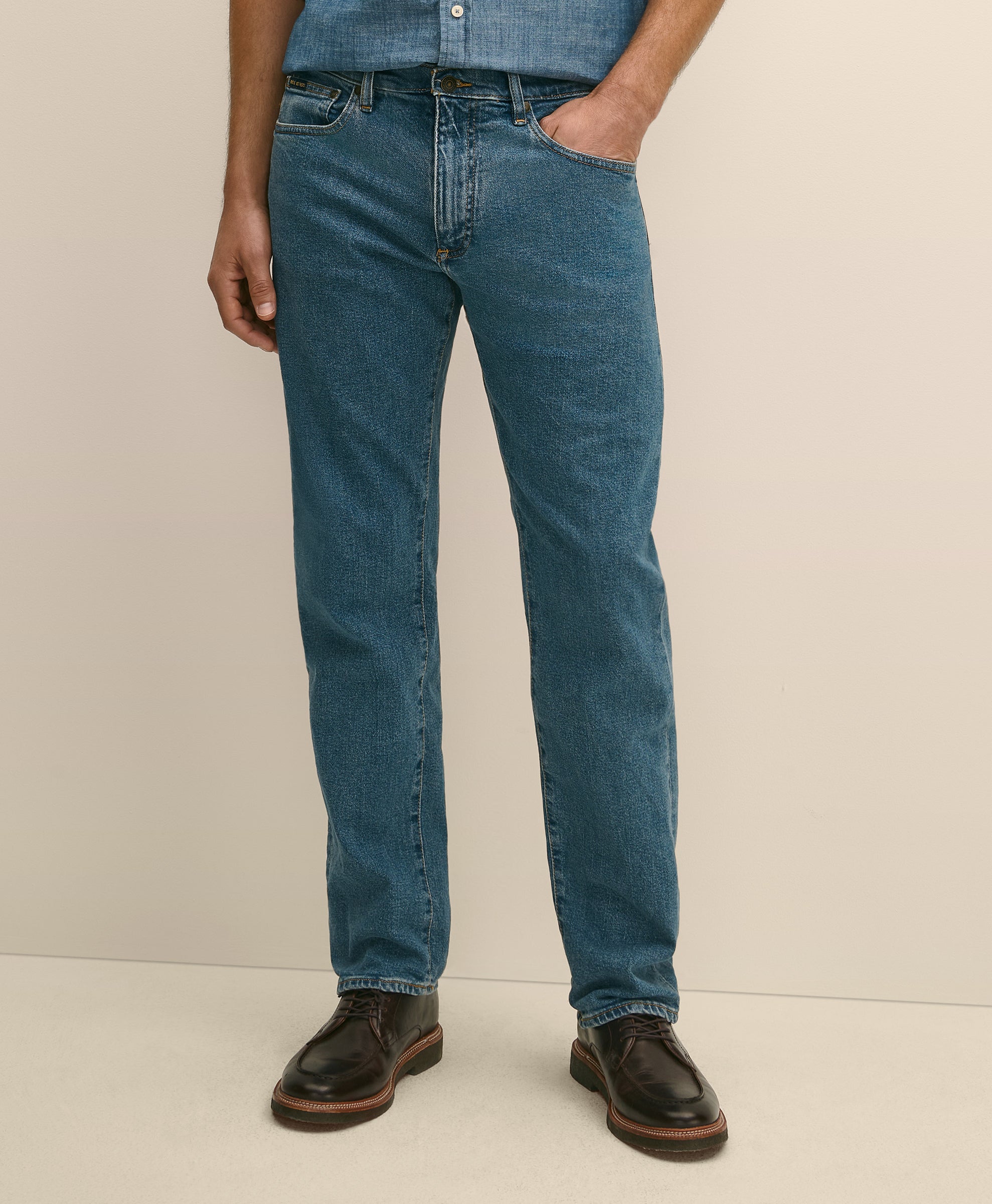 Person wearing blue jeans and brown shoes