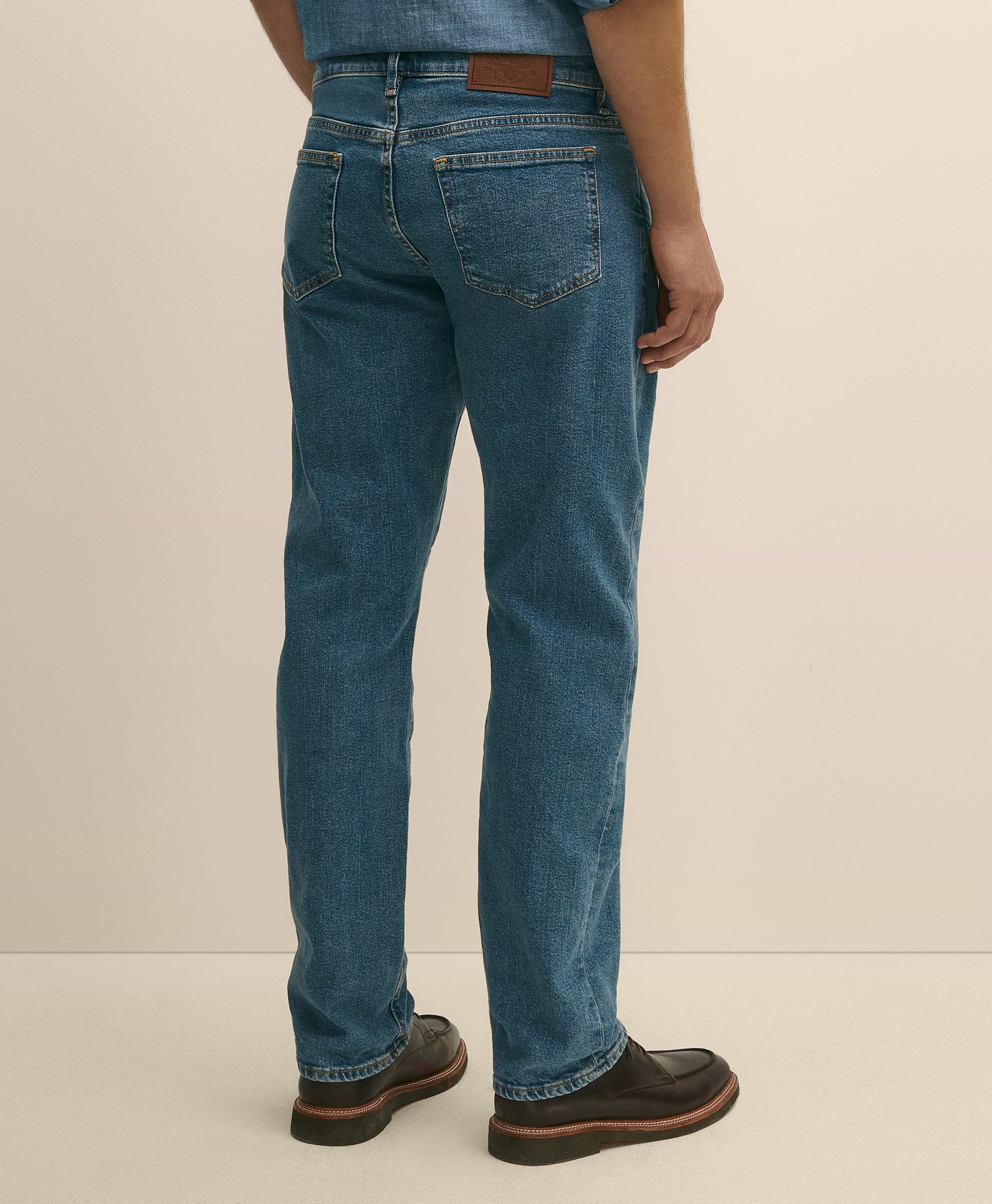 Person wearing blue jeans and brown shoes