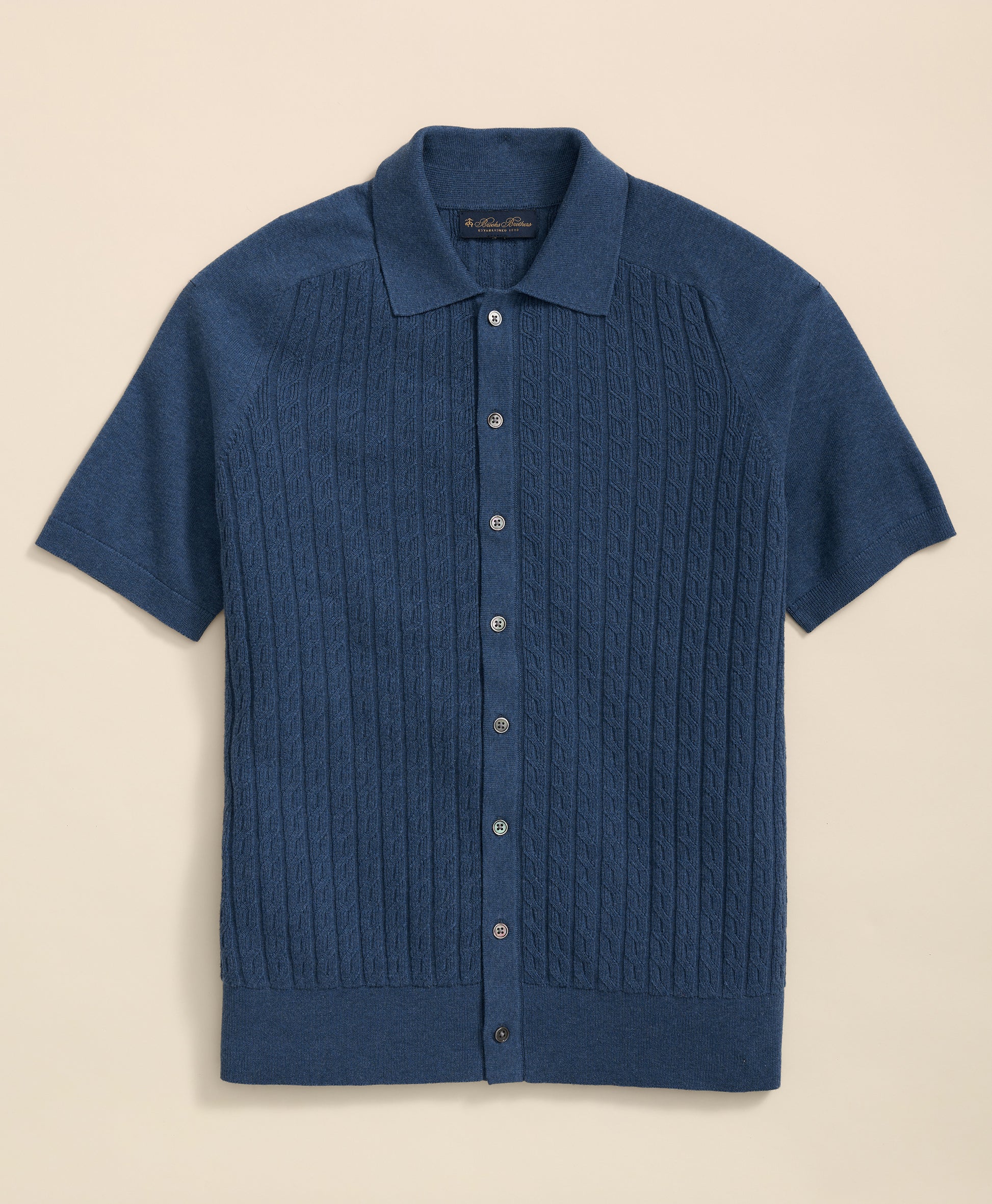 Blue short-sleeve knit shirt on a beige background