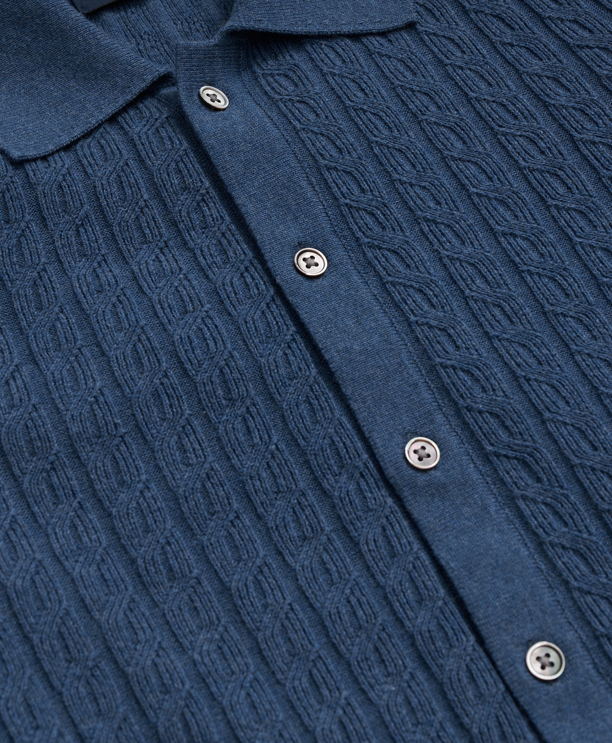 Close-up of a blue textured shirt with buttons
