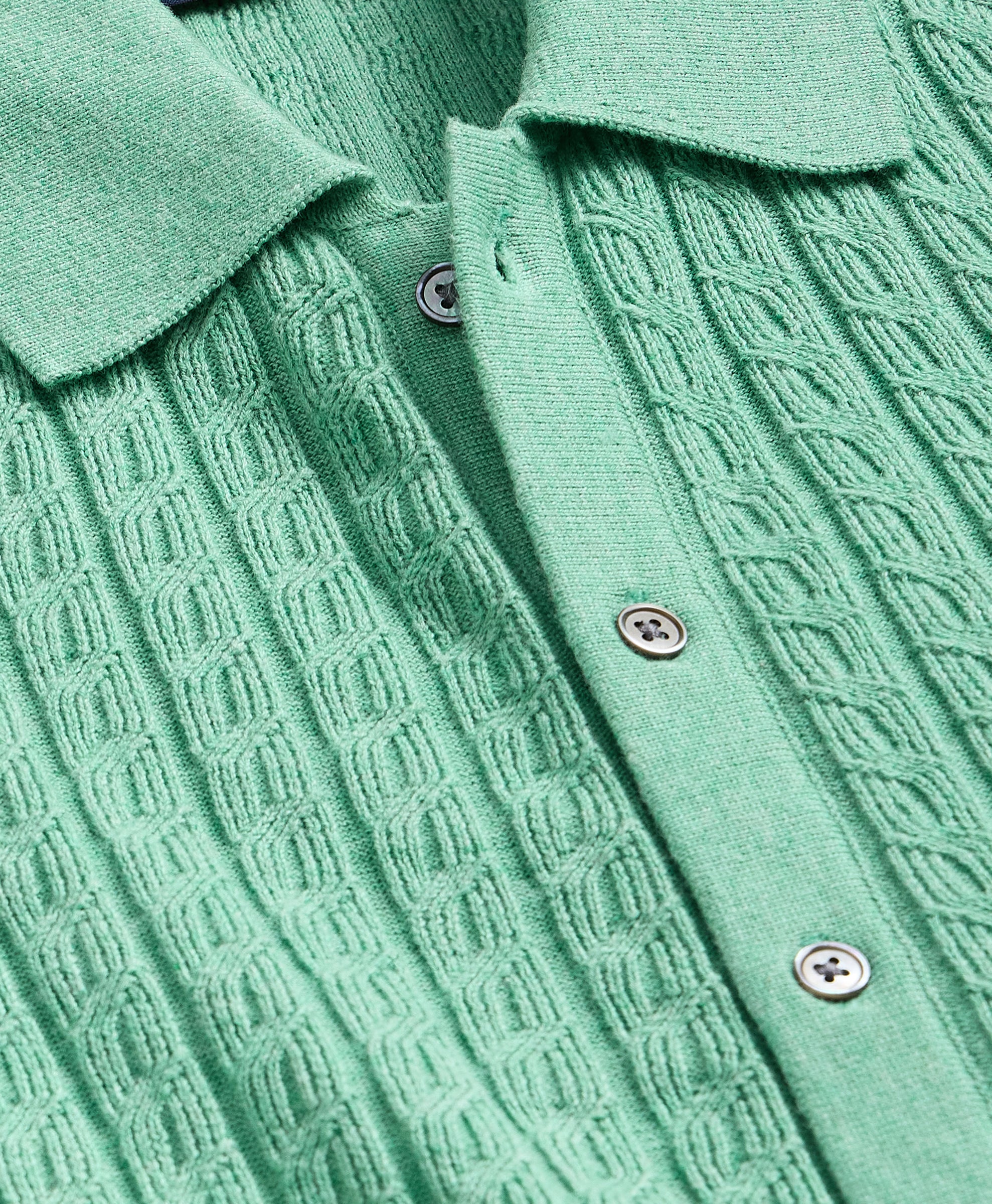Close-up of a green textured shirt with buttons