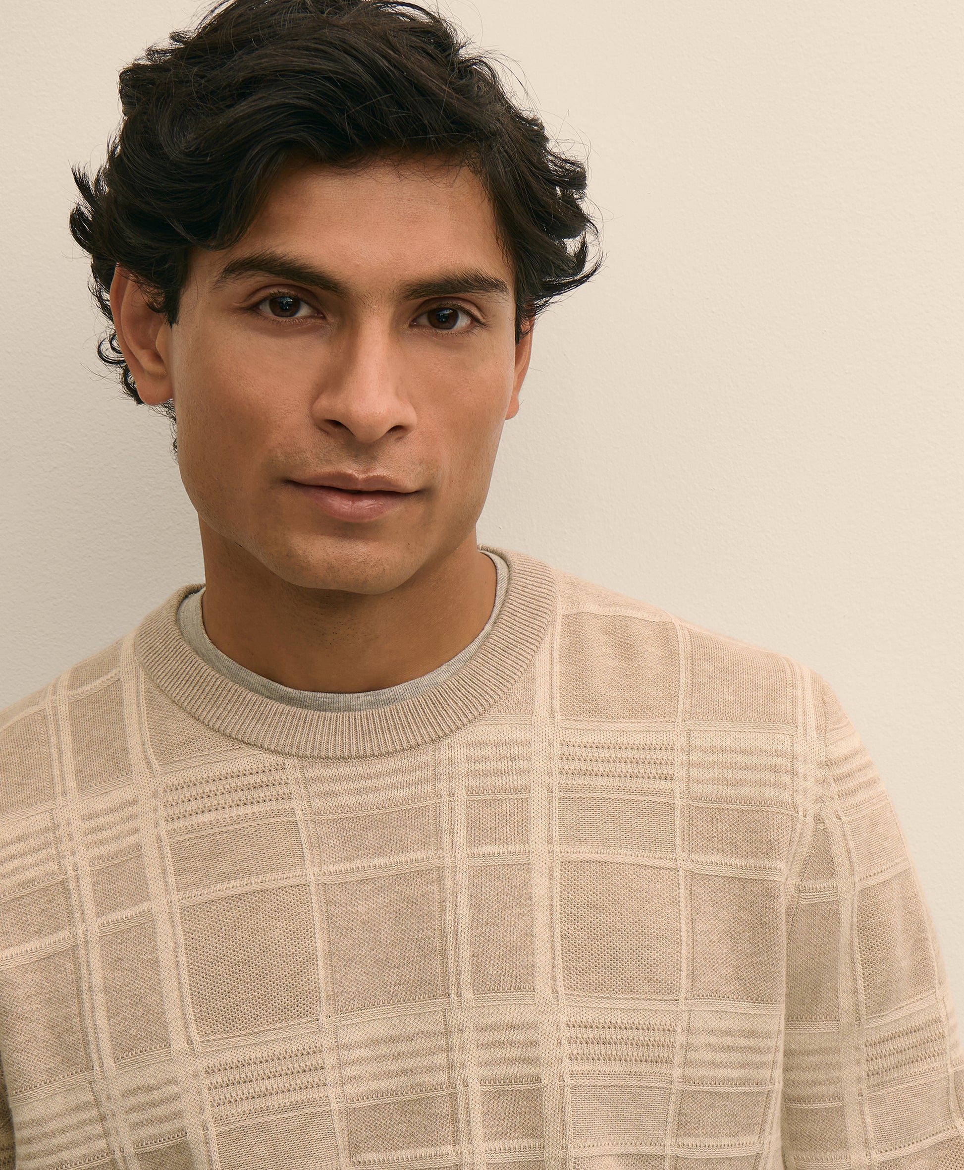 Man wearing a beige checkered sweater