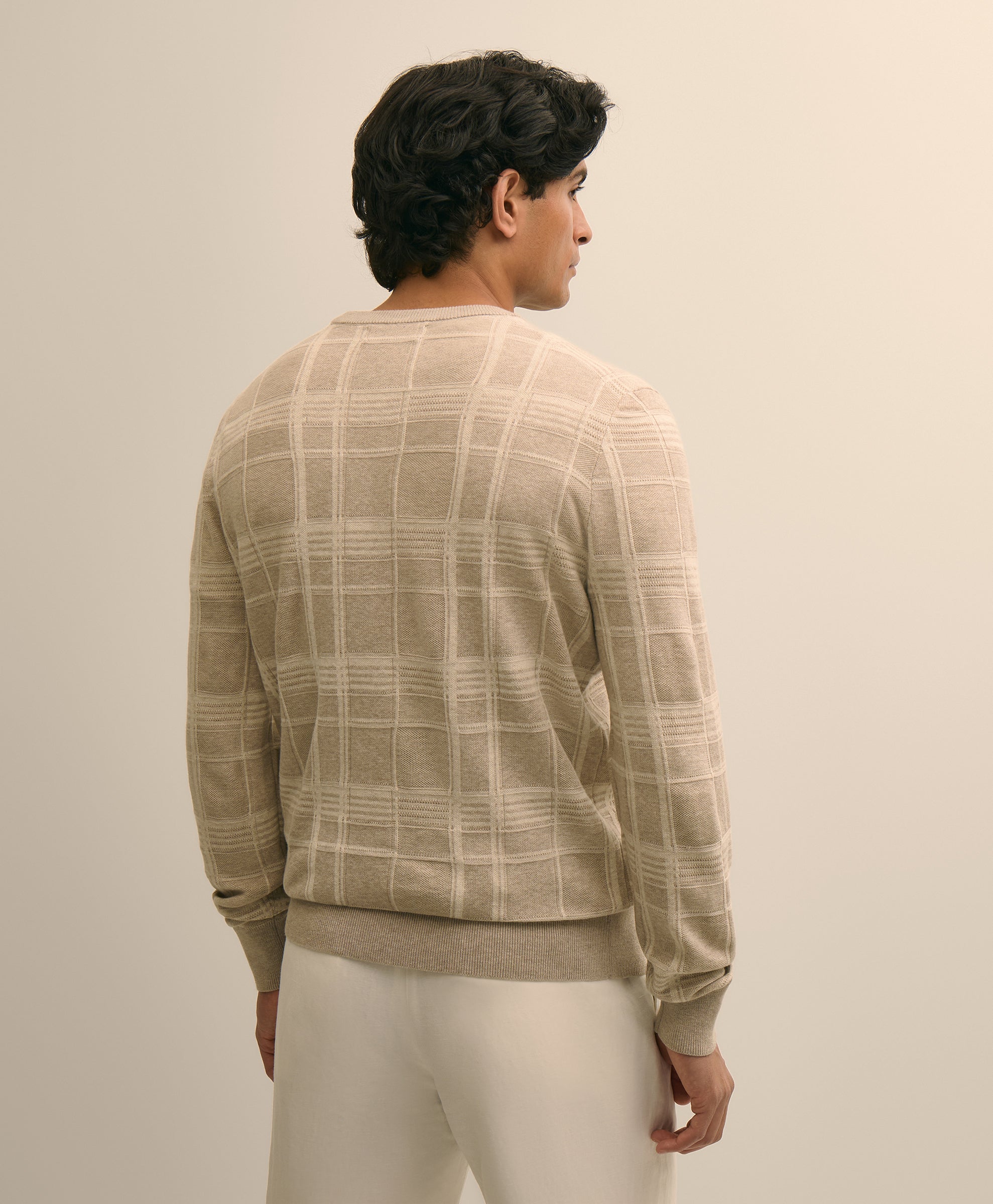 Person wearing a beige checkered sweater