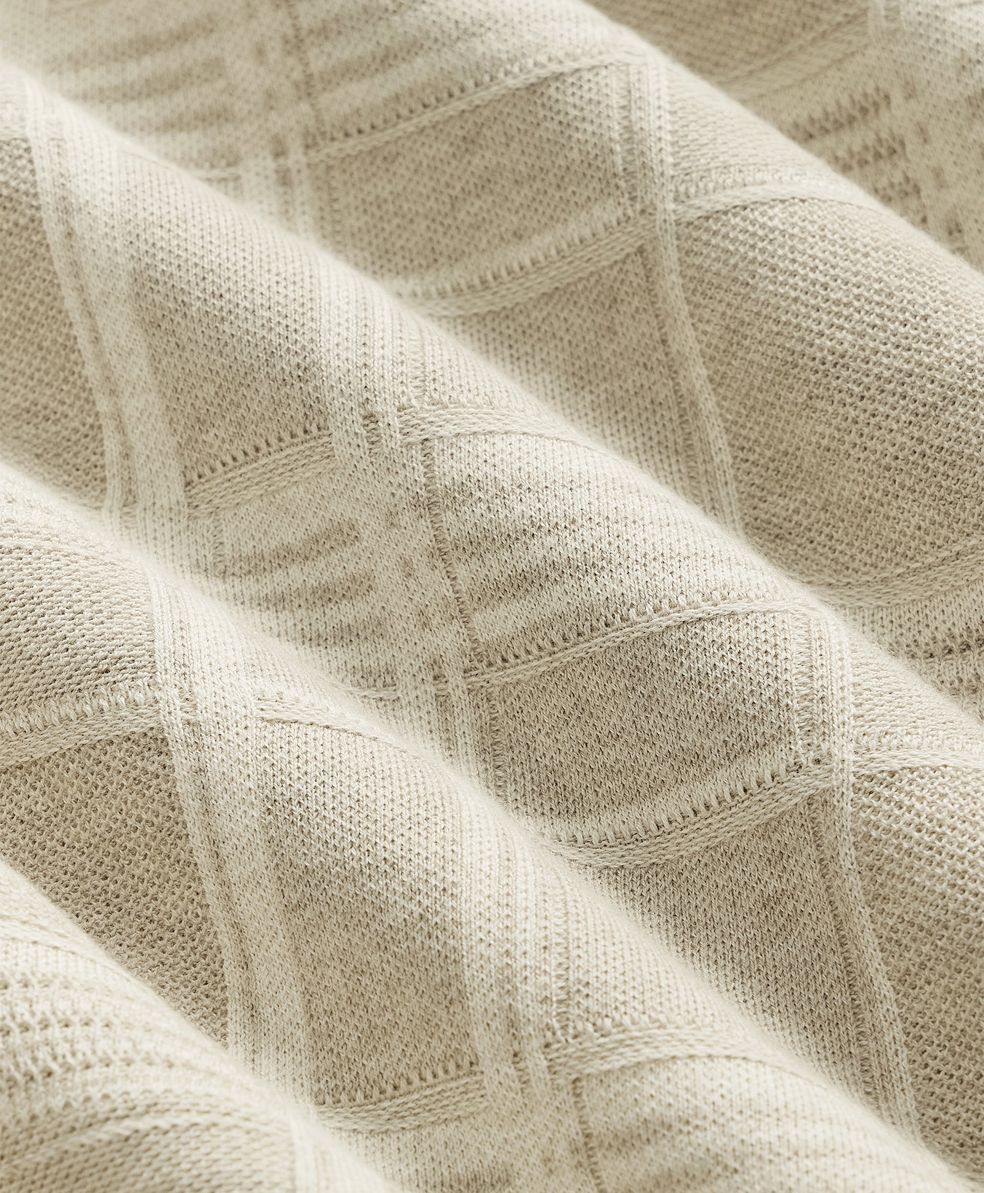 Close-up of textured beige fabric with a subtle pattern