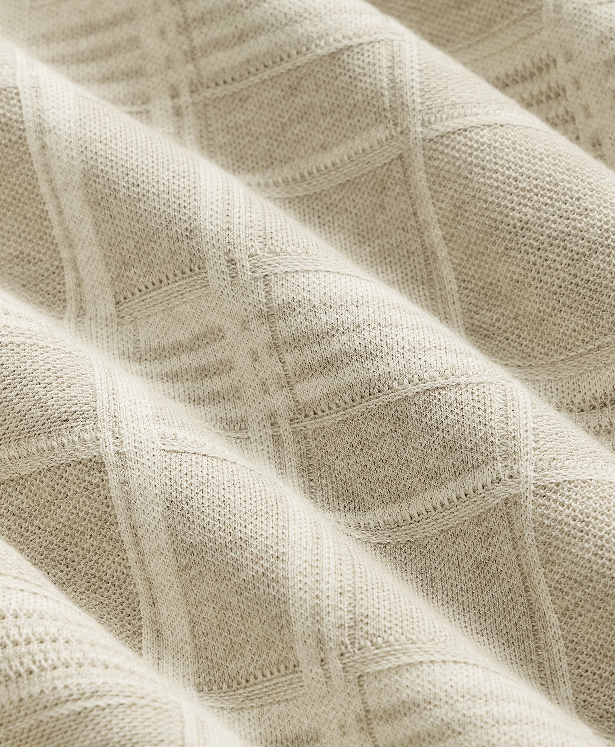 Close-up of textured beige fabric with a subtle pattern