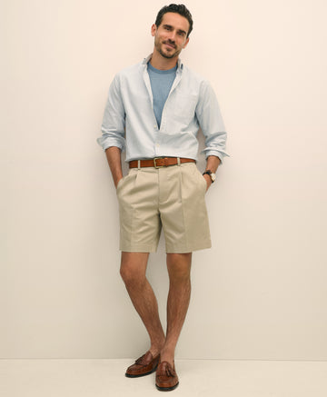 Man wearing a light blue shirt, beige shorts, and brown shoes